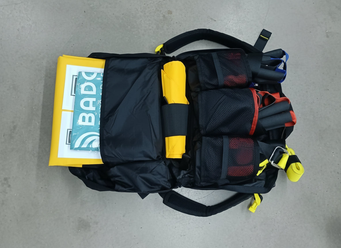 Black and yellow safety harness with a BADO logo on a brown floor.