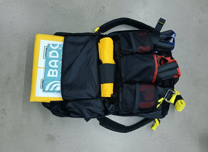 Black and yellow safety harness with a BADO logo on a brown floor.