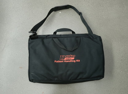 Black patient handling kit bag with red text on a brown surface
